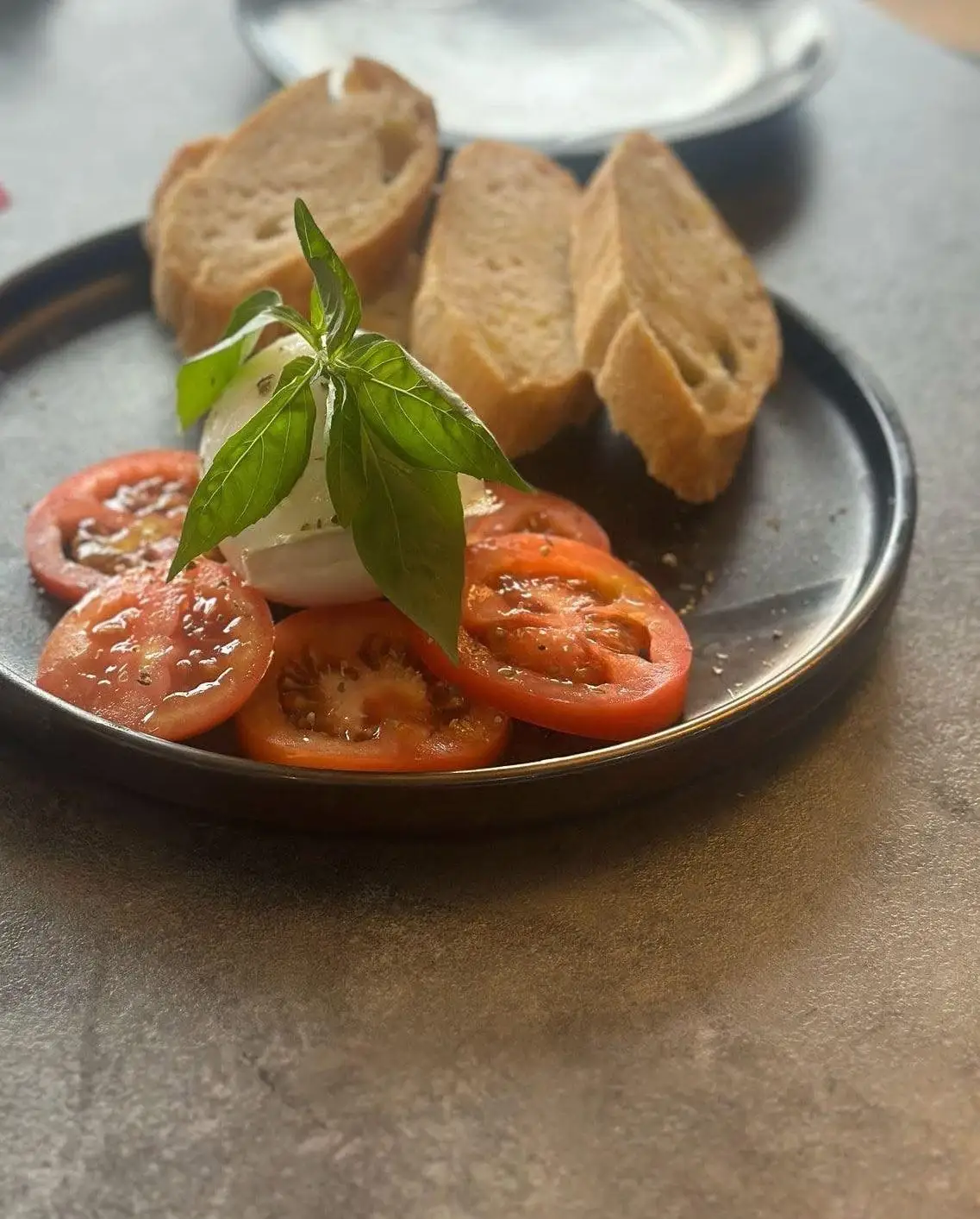 Mozzarella with basil on sliced tomatoes, olive oil and toasted bread